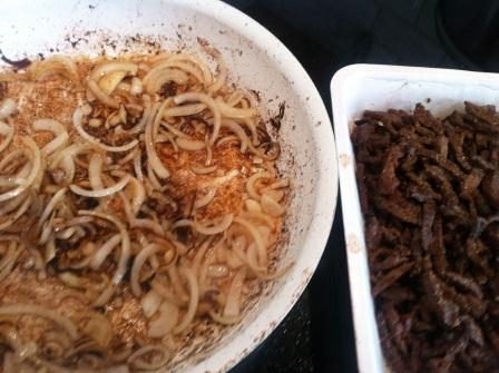 Till höger ligger det stekta köttet, medan löken steks i pannan